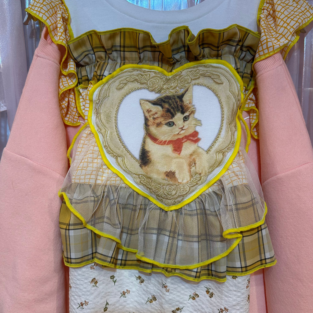 黄色のチェック柄とピンクの猫柄のスウェットシャツ